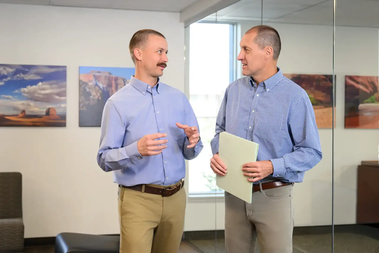 Two attorneys discussing a case file in the office